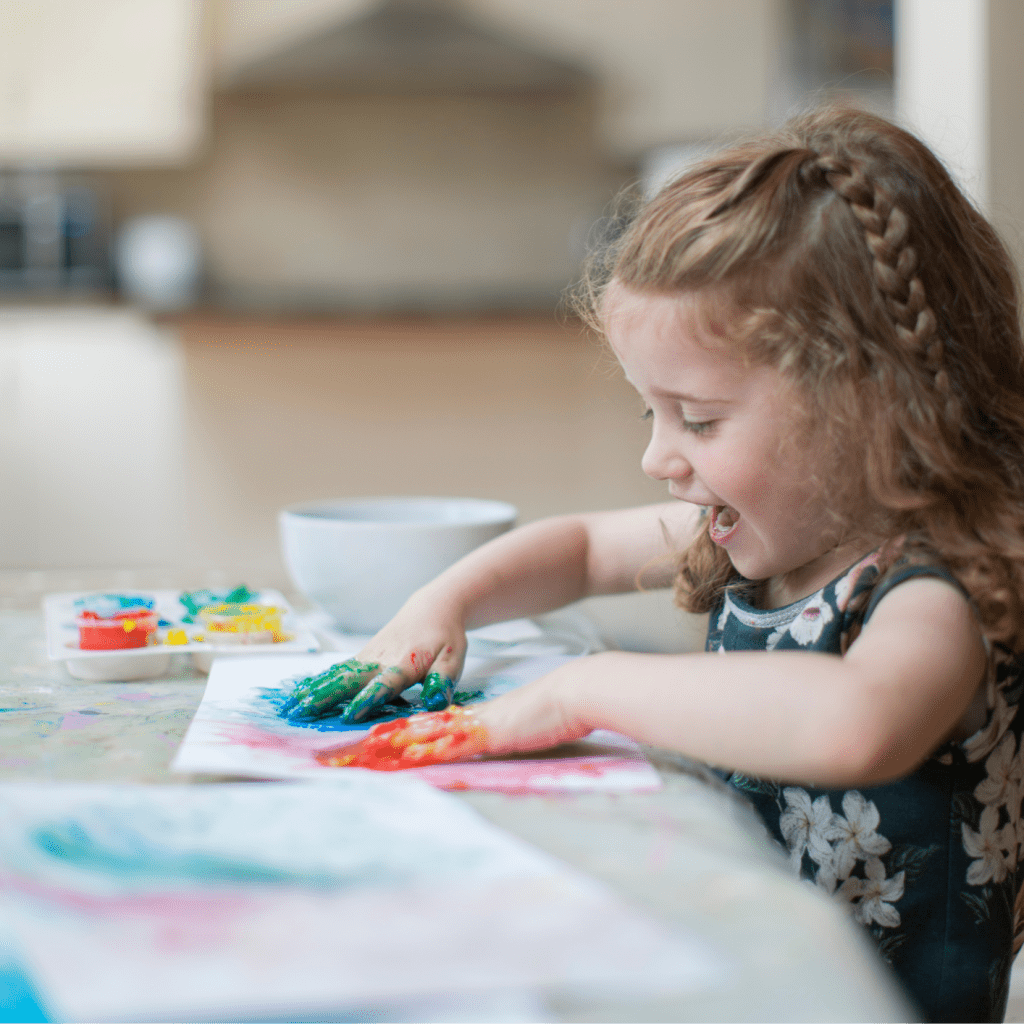 Petite fille qui fait de la peintures avec ses mains