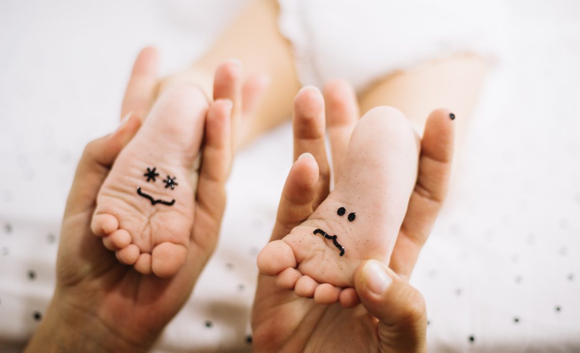 Empreinte pied bébé avec dessin souriant sur la plante des pieds
