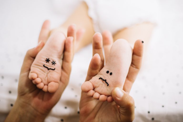 Empreinte pied bébé avec dessin souriant sur la plante des pieds