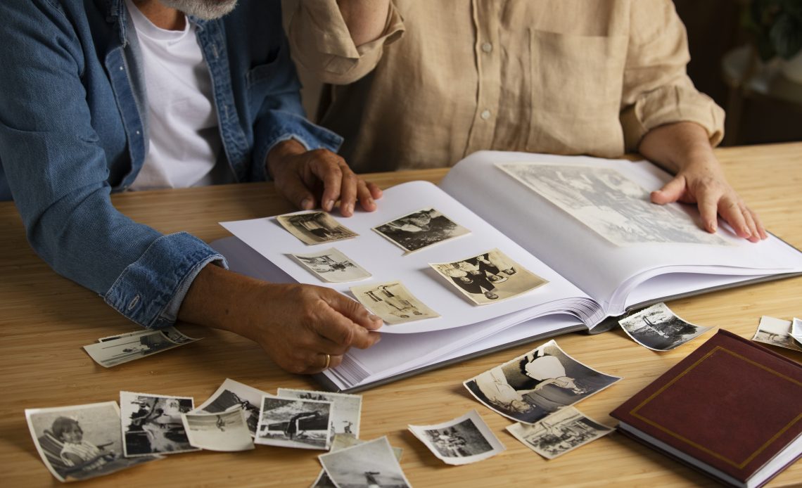 Photographie d’une famille intergénérationnelle posant pour un portrait à domicile. Les grands-parents, les parents et les enfants sont réunis pour capturer un moment de souvenir familial.