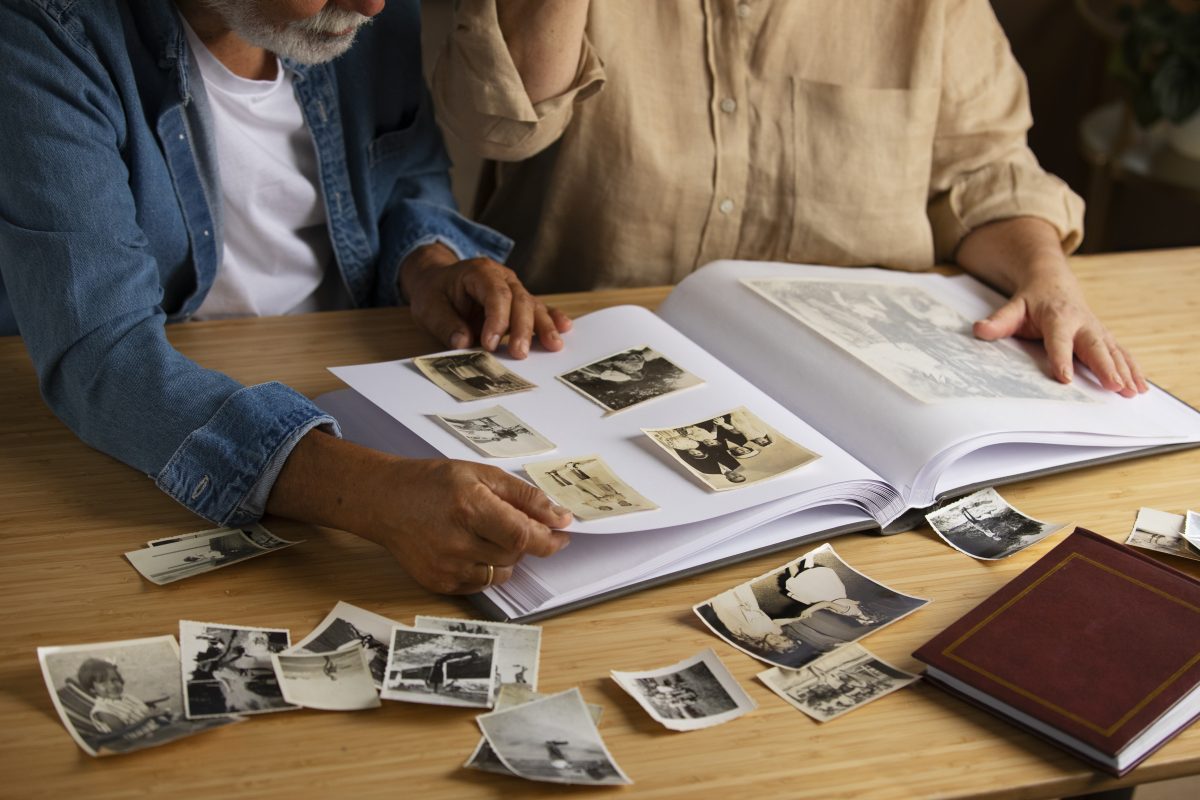 Photographie d’une famille intergénérationnelle posant pour un portrait à domicile. Les grands-parents, les parents et les enfants sont réunis pour capturer un moment de souvenir familial.