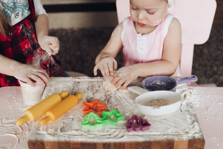 Enfants jouant avec de la pâte et des emporte-pièces lors d’une activité créative en cuisine